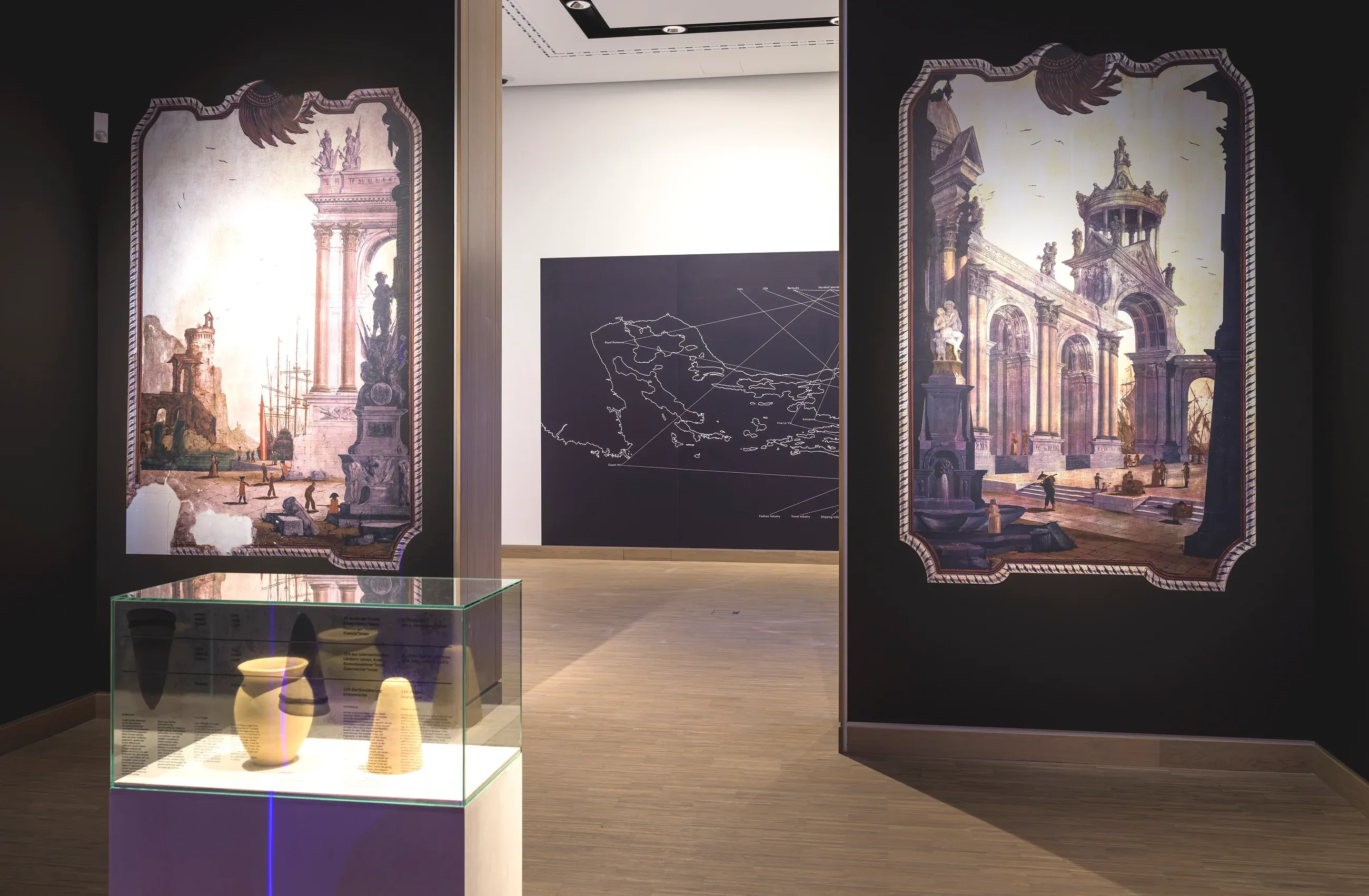 Two prints of the vedute on dark walls, with a vitrine of sugar moulds in front