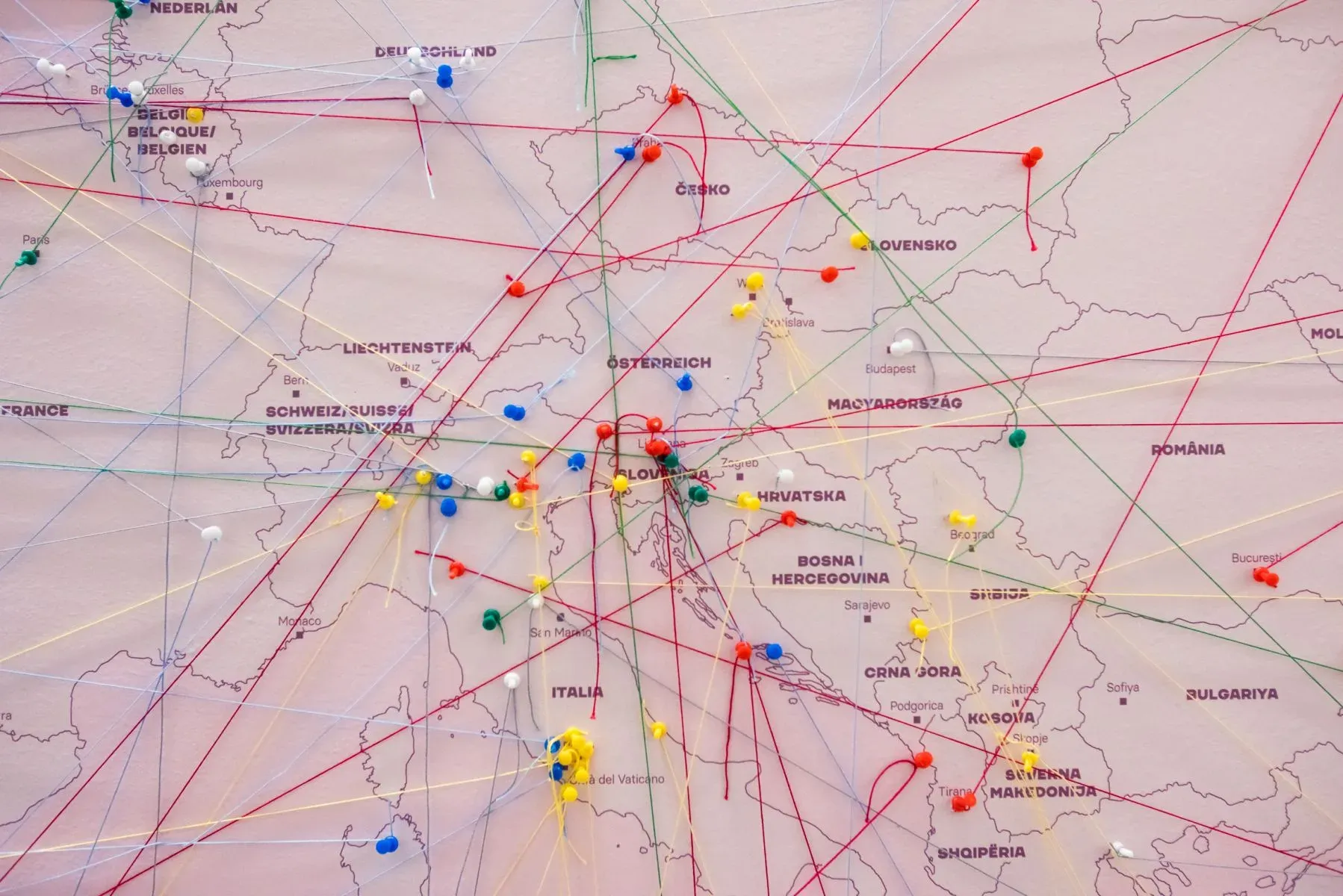 Pins and coloured threads connecting cards to places on the map