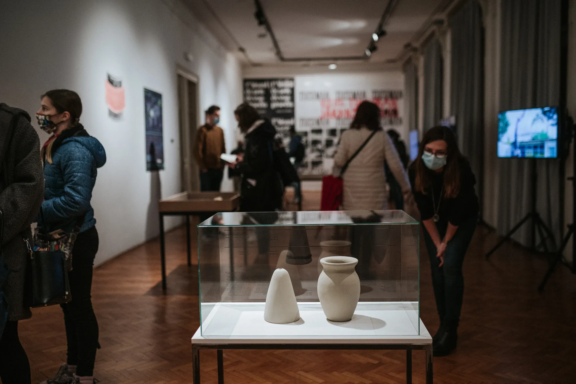 Visitors around a vitrine with a sugar mould and a jar