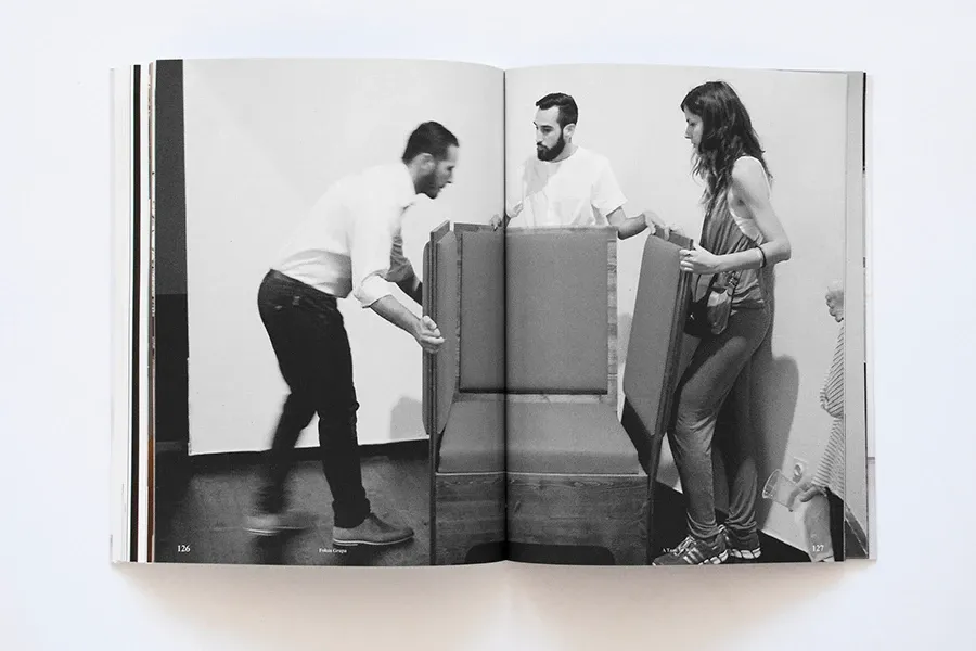 A black-and-white photograph of two people folding the furniture