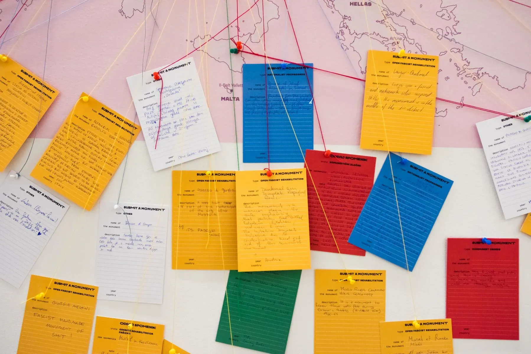 Handwritten cards in yellow, blue, red and green pinned to the map